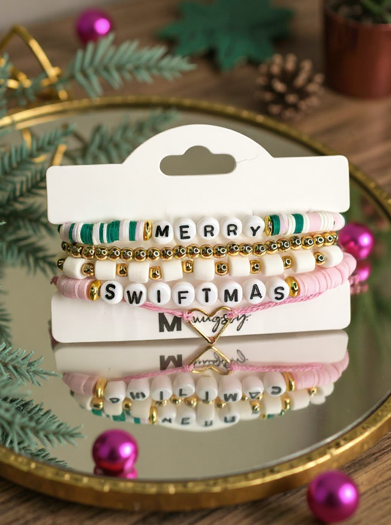 Set of bracelets with festive text on a white card, surrounded by Christmas decorations.