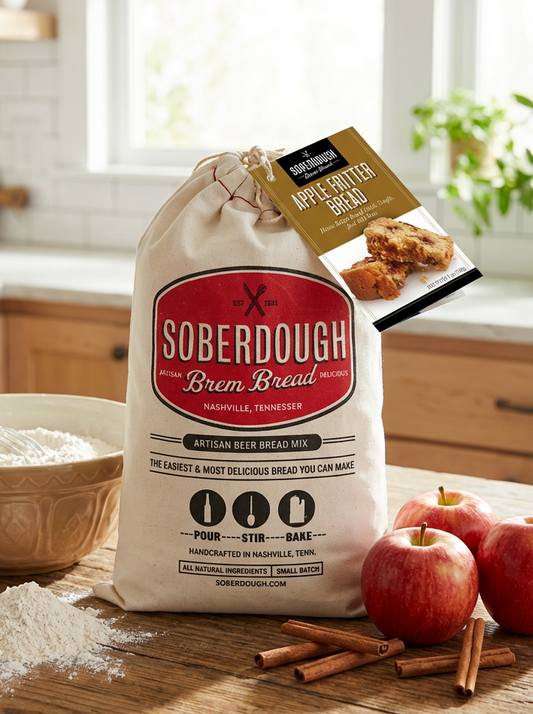 Bag of Soberdough Brem Bread mix on a kitchen counter with apples and cinnamon sticks.