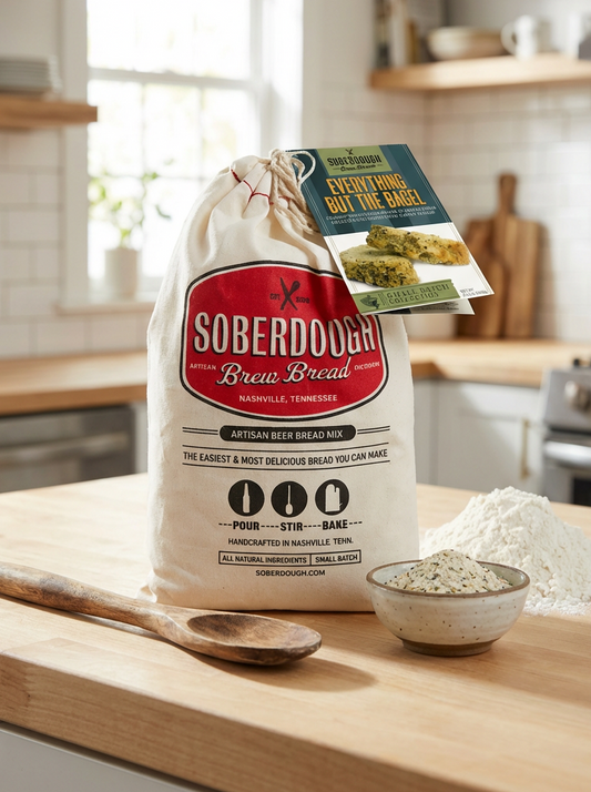 Bag of Soberdober Brew Bread on a kitchen counter with a wooden spoon and bowl of flour.