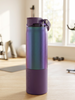 Purple water bottle on a wooden floor with gym equipment in the background