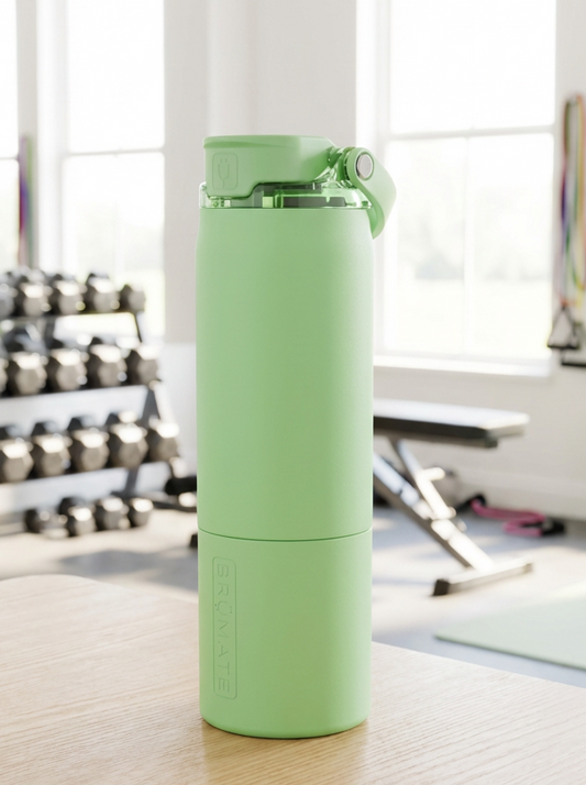 Green water bottle on a wooden floor in a gym setting